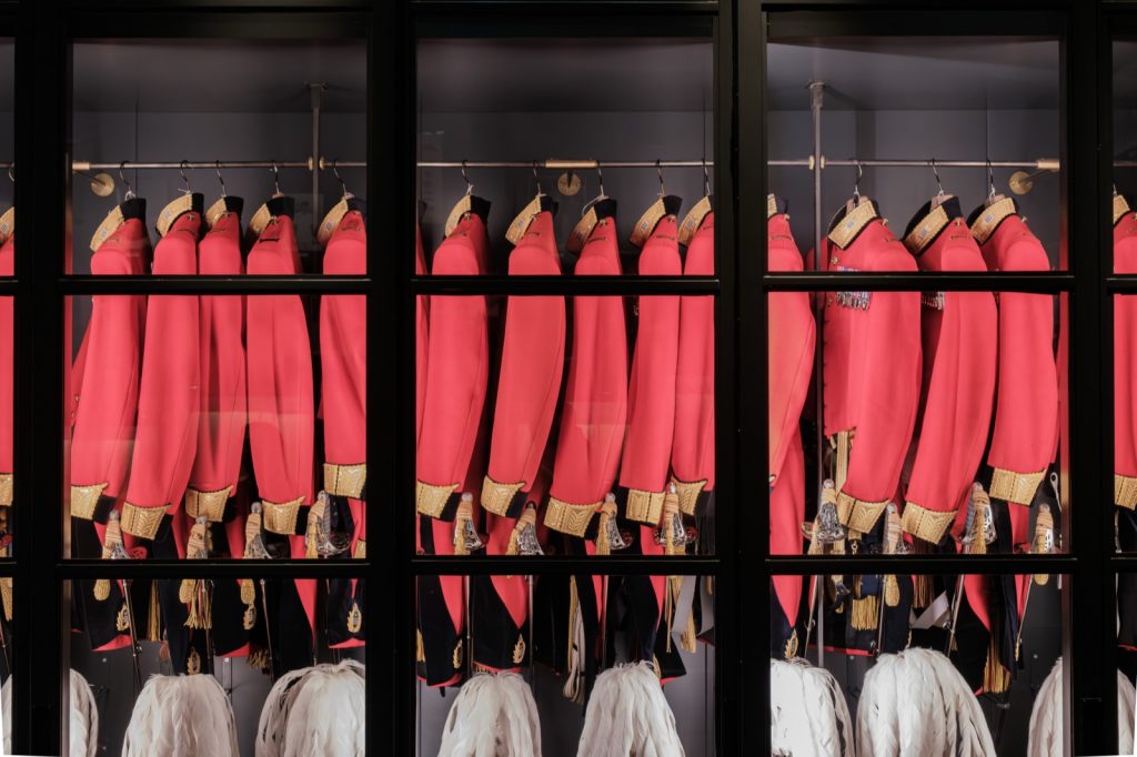 ガラス越しに並ぶ、金モールの肩章が付いた赤い軍服と、下段に吊るされたサーベル