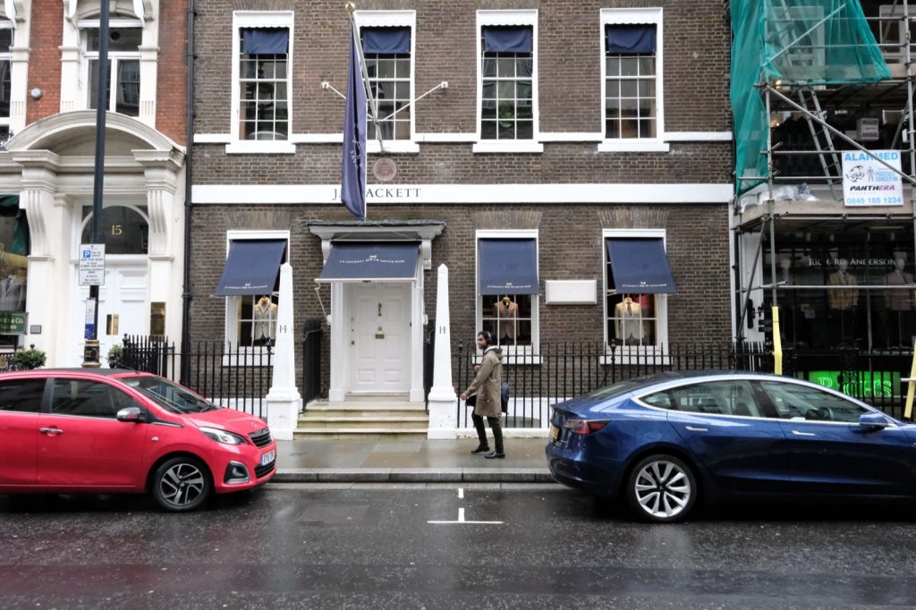ロンドン、サヴィル・ロウ14番地に建つJP Hackettの外観。紺のオーニングと社旗が下がるレンガ造りの建物